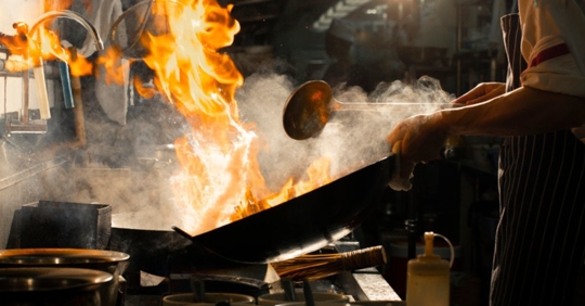 cooking with fire in restaurant kitchen